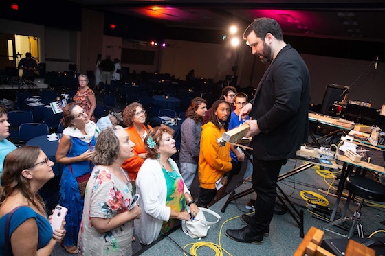 Adam Sliwinski showing the unusual instruments used in the Dessner piece to the audience