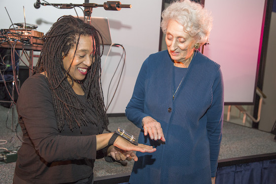 Pamela Z demonstrating a gesture controller to an audience member after our concert